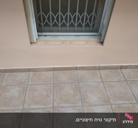 רצפת אריחים מול חלון עם סורגים